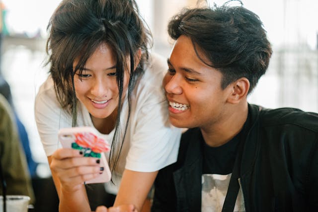 Two happy people looking at a smartphone screen